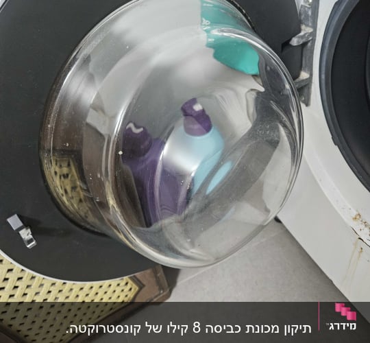 דלת מכונת כביסה פתוחה עם בקבוקי חומרי ניקוי